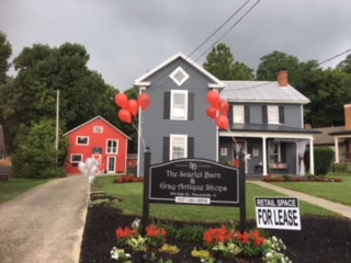 gray building with a red barn