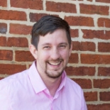 picture of a man in front of brick wall